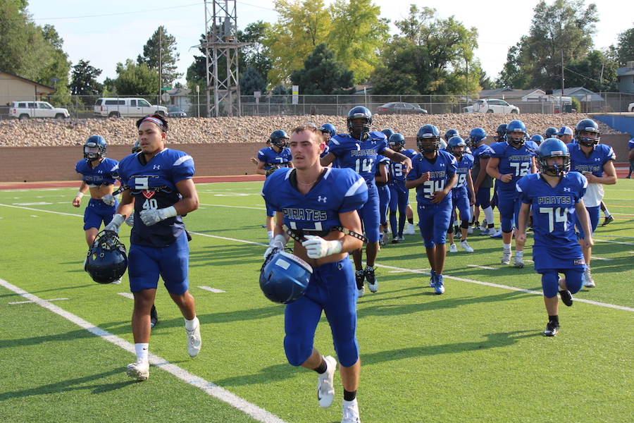 Number 3 Ikaika Gonzales and number 12 Terryn Bacca run toward the sideline ahead of the scrimmage.