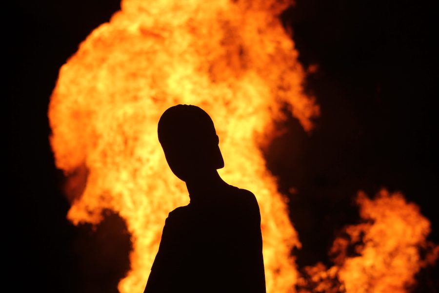 An EHS student poses in front of the bonfire.