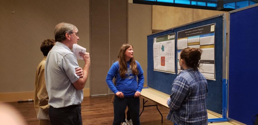 Senior Paige Lincoln-Rohlfing presents her poster to CSU math experts.