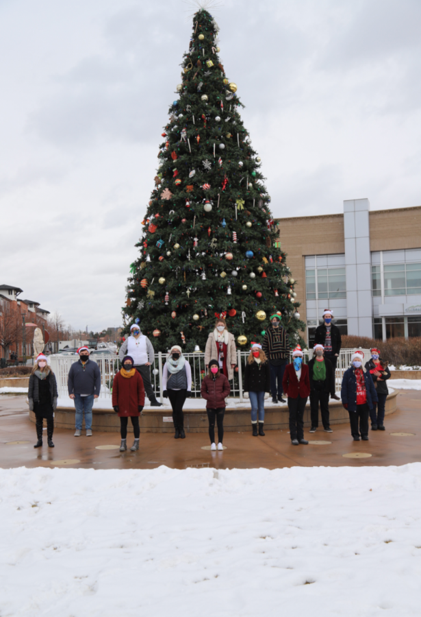 Carol of the bells Choir stands in front of the Englewood holiday tree.