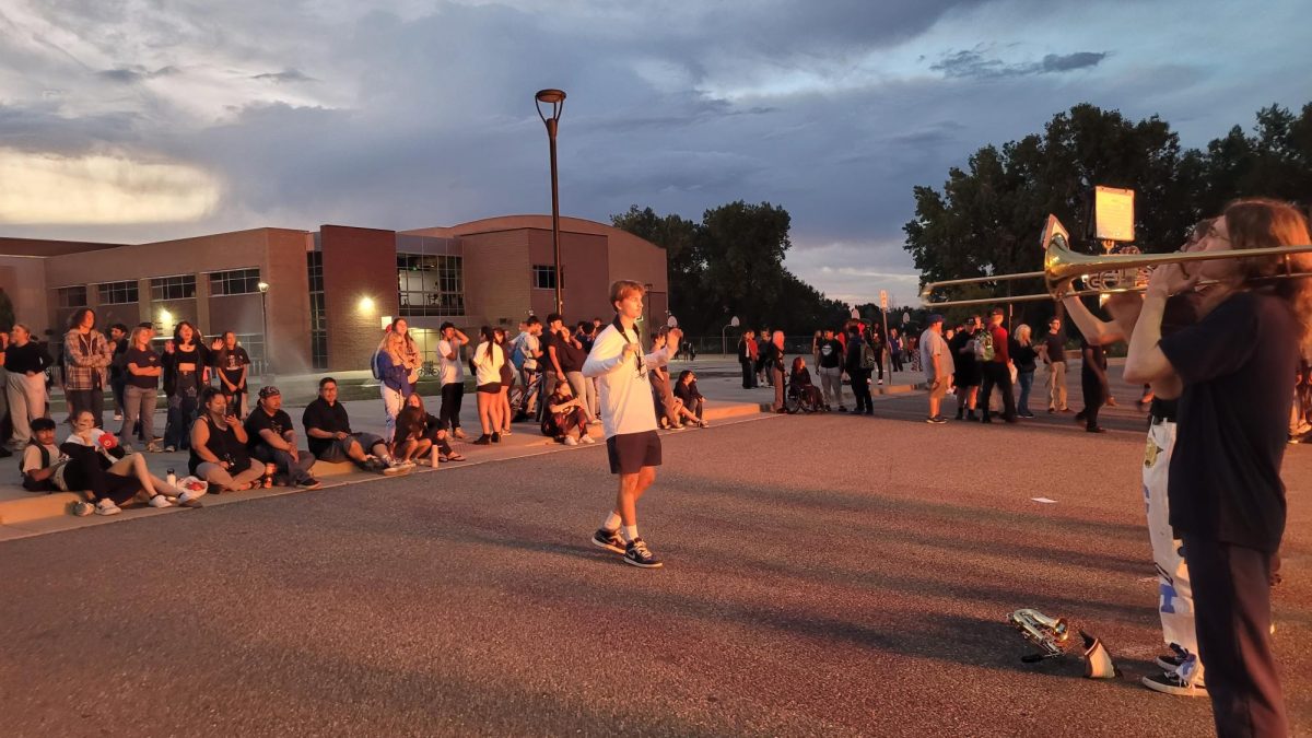 The band played the fight song as students stood around, basking in the light of the bonfire. 