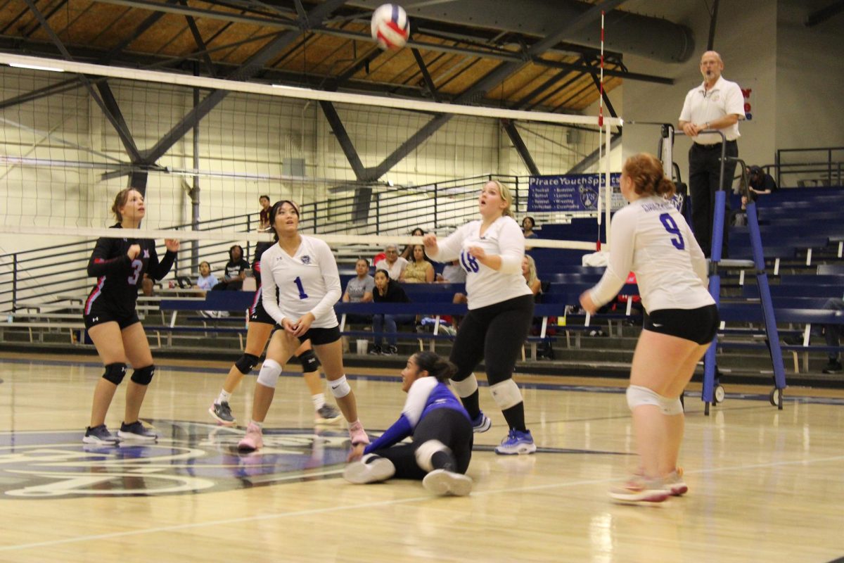 Kira Cole, Naomi Vazquez, and Bella Lubbers work well together getting the point after a hard serve. 