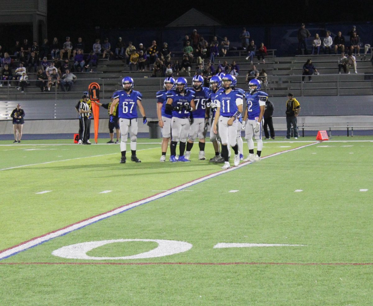 The offense gets cues from the sideline during the Homecoming game against Littleton. 