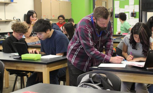 Jackson Rowland walks around the classroom helping students in chemistry.