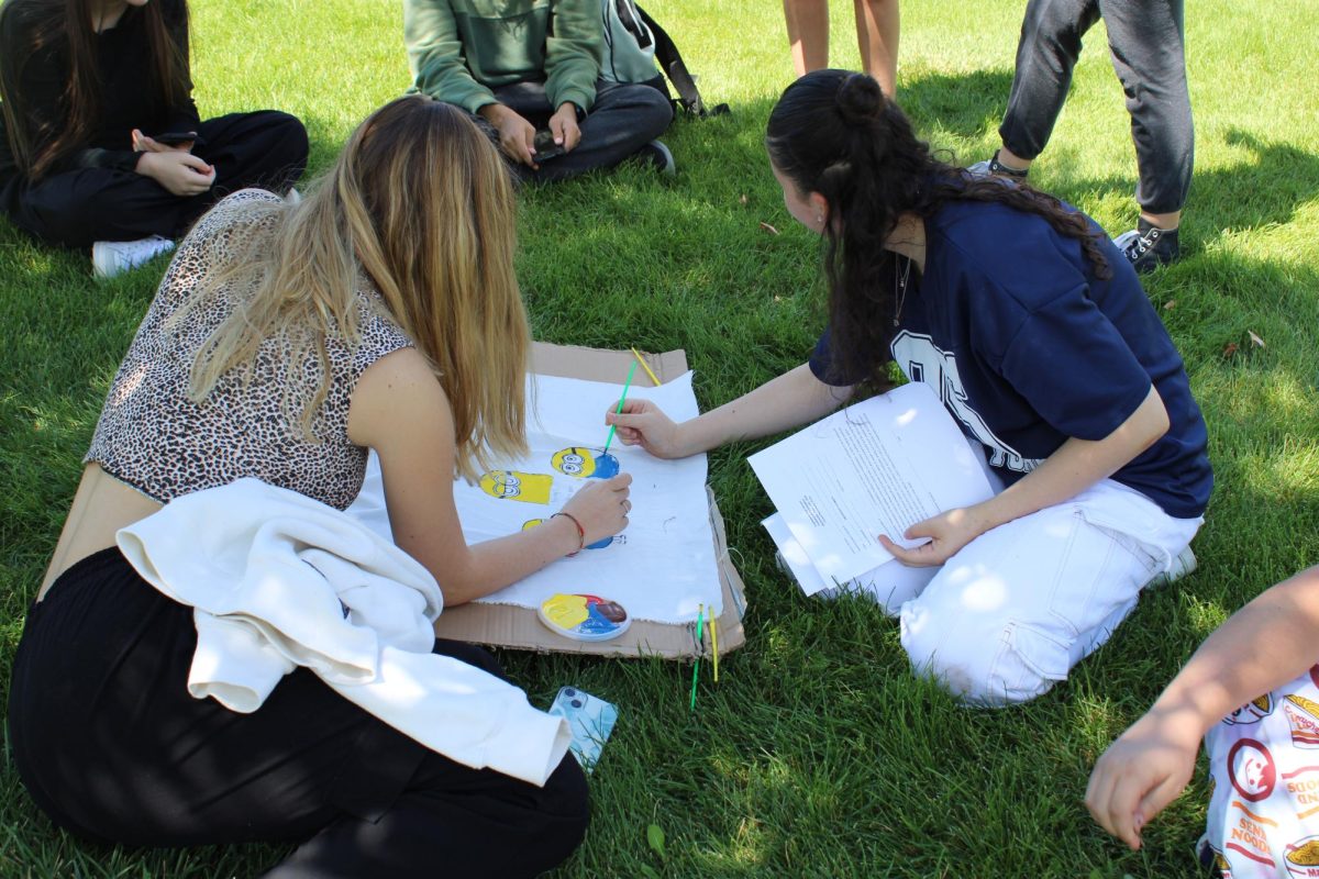 Seminar students paint flags to represent their seminar class and a slogan the class came up with that reflects their school spirit and class personality. 