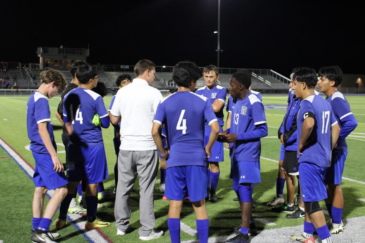 Boys varsity soccer holds a team huddle after the latest game. The players talk about how the game went and hype the team for the next outing. 