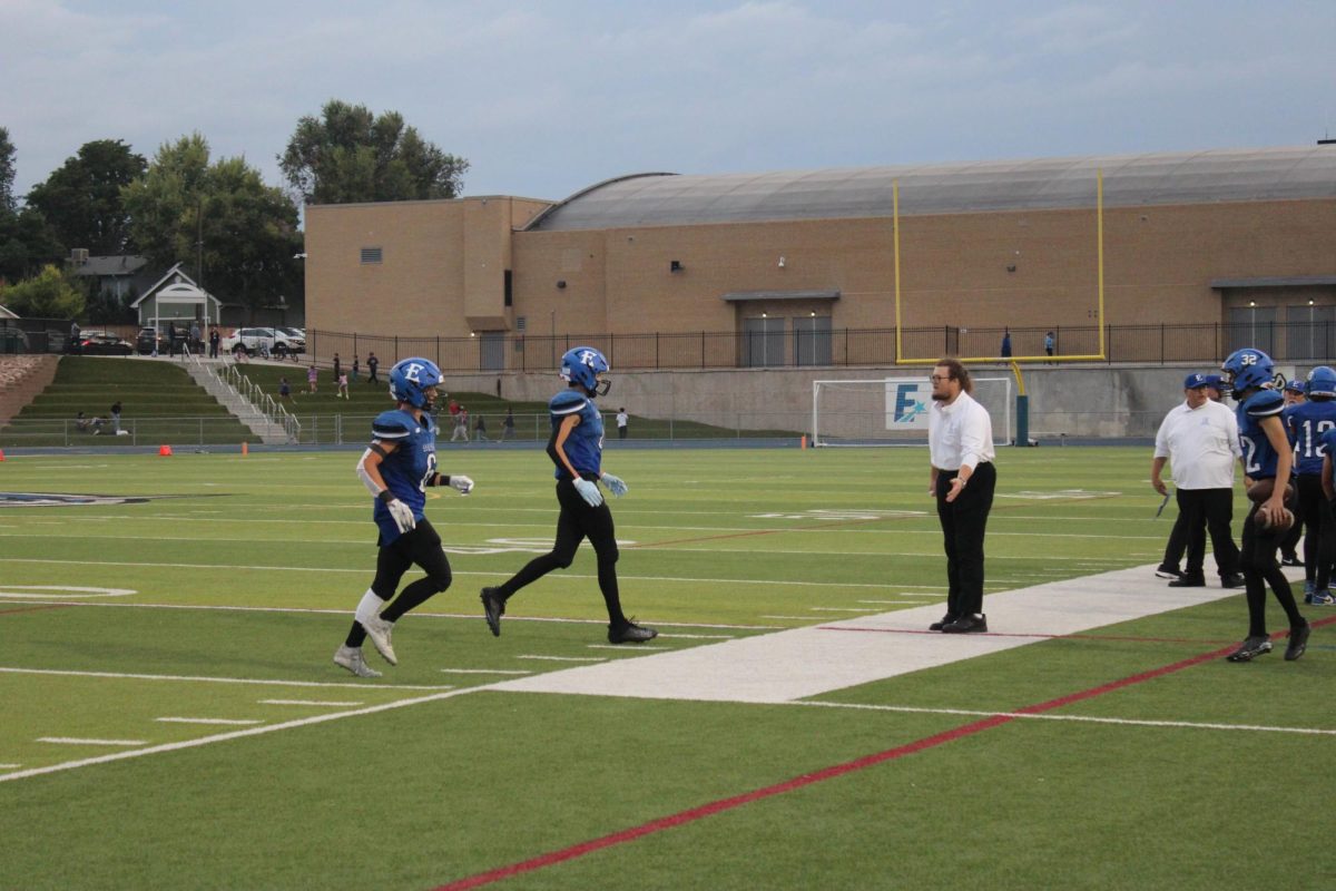 Line Coach TJ Callihan congratulates members of the EHS football offensive line during the game against Hinkley High on August 29, 2025. 