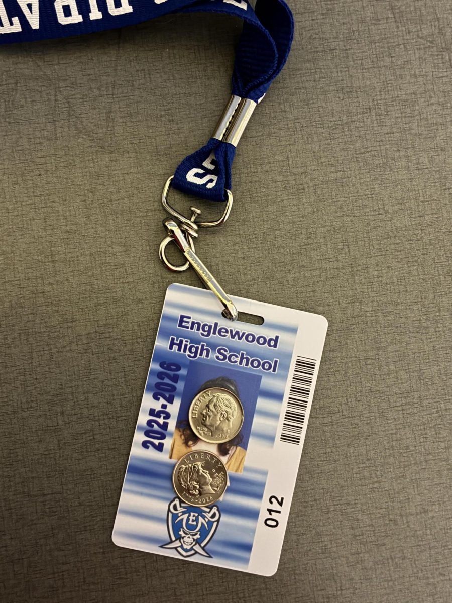 Student ID card with two dimes covering the face and the name